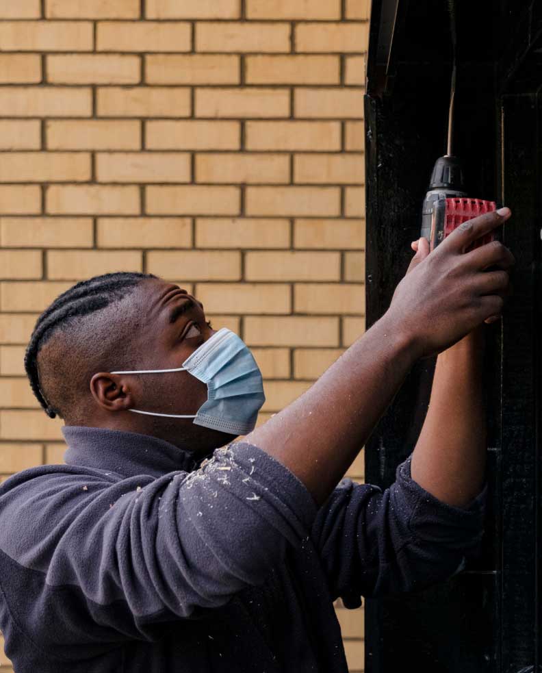 A young man undertakes some DIY with a drill
